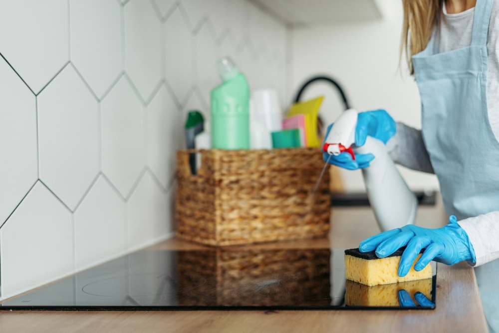 woman cleaning a glass top stove