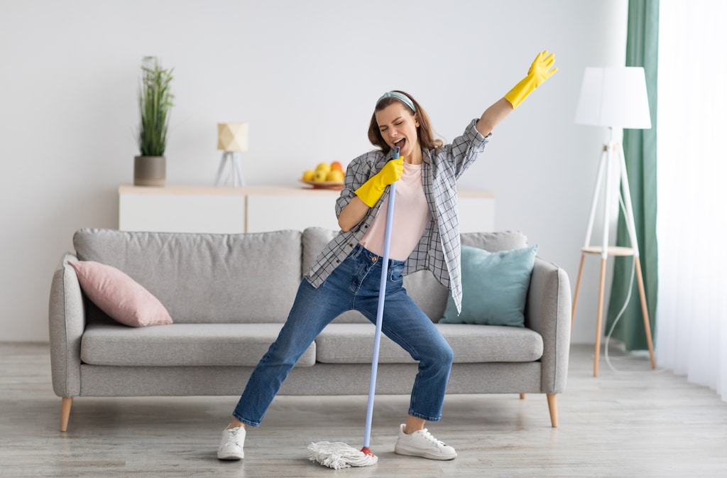 happy young woman is cleaning an Airbnb