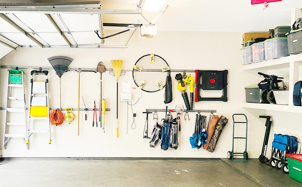A garage shows nearly organized wall storage and storage containers.